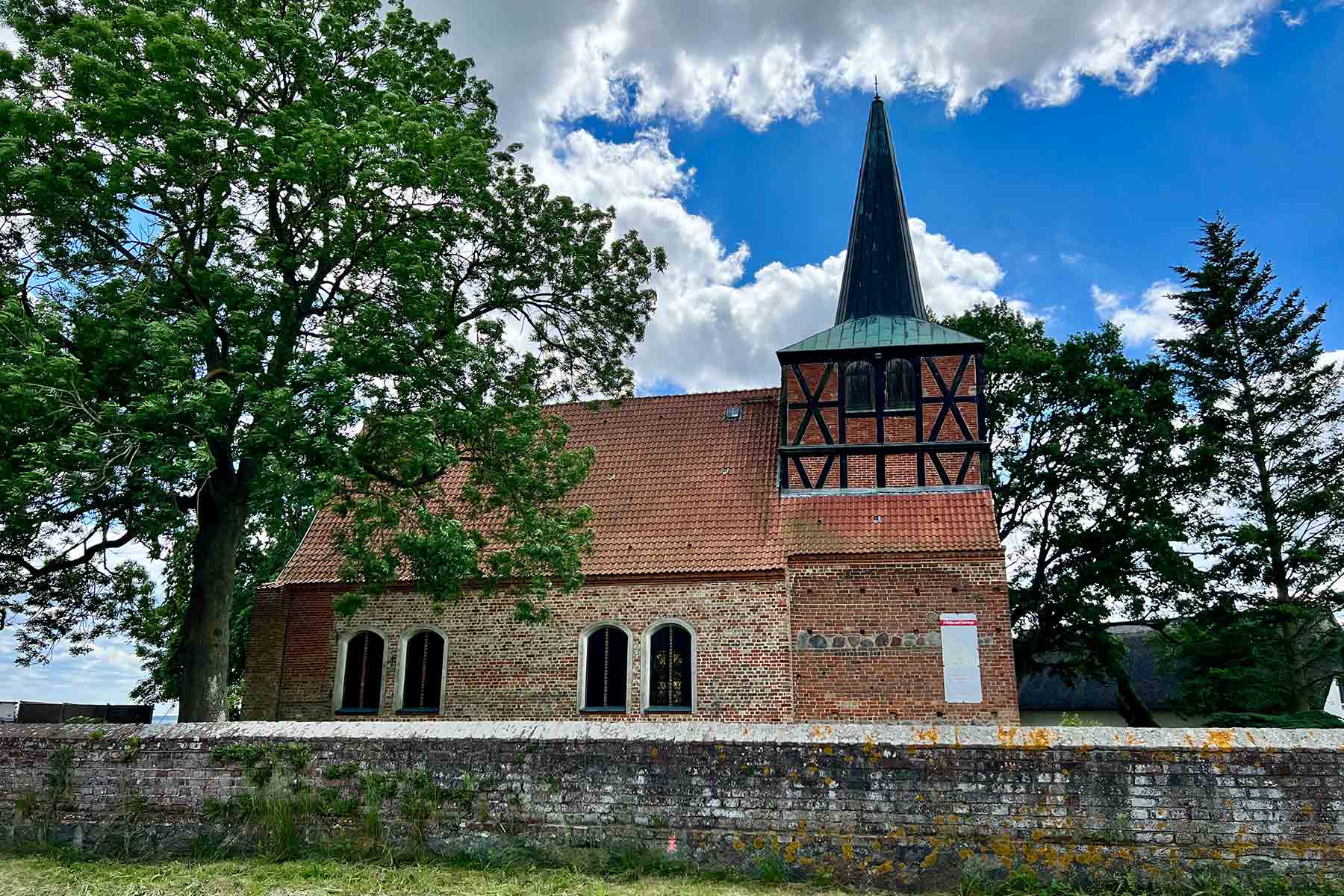 Spätgotische Dorfkirche in Mönchow mit Mausoleum von der Straße aus
